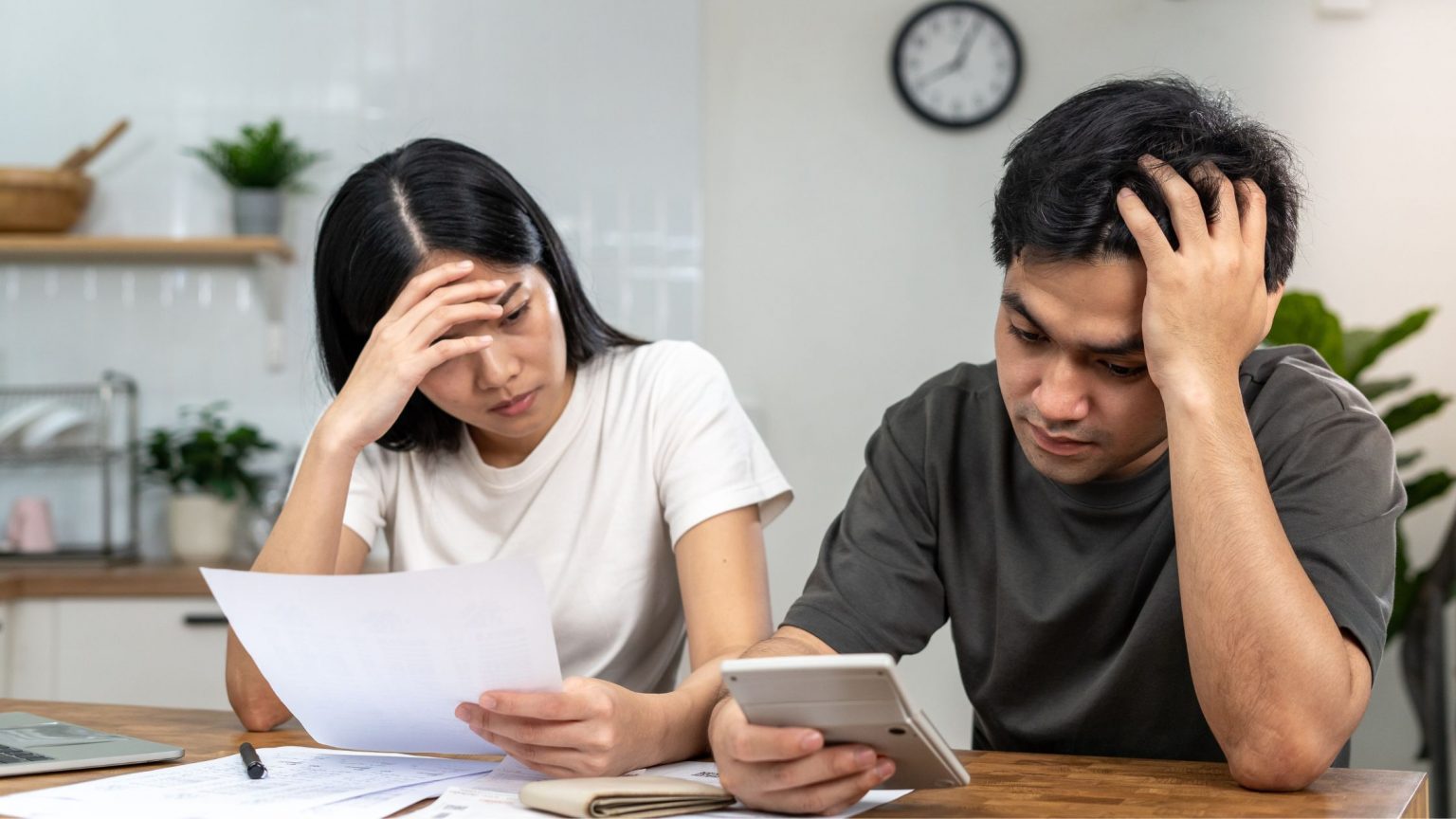 Couple looking stressed as they evaluate their credit card bills.