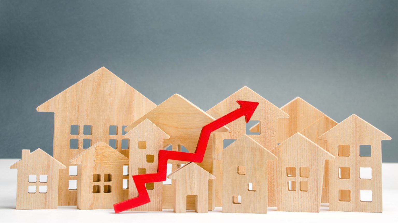 House figurines and red increasing arrow to show FHA loan limit increase.