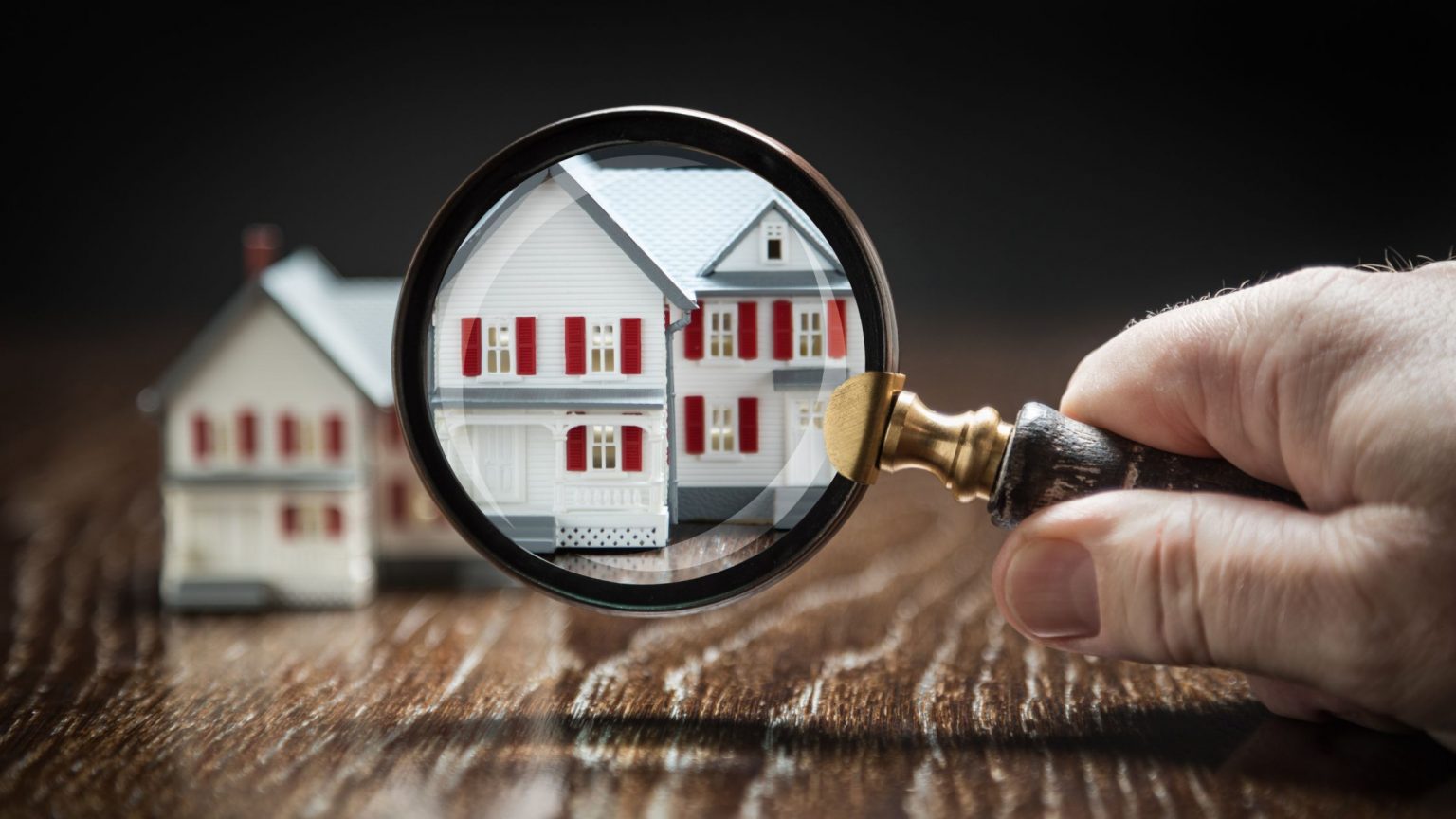 Magnifying glass looking at a house.