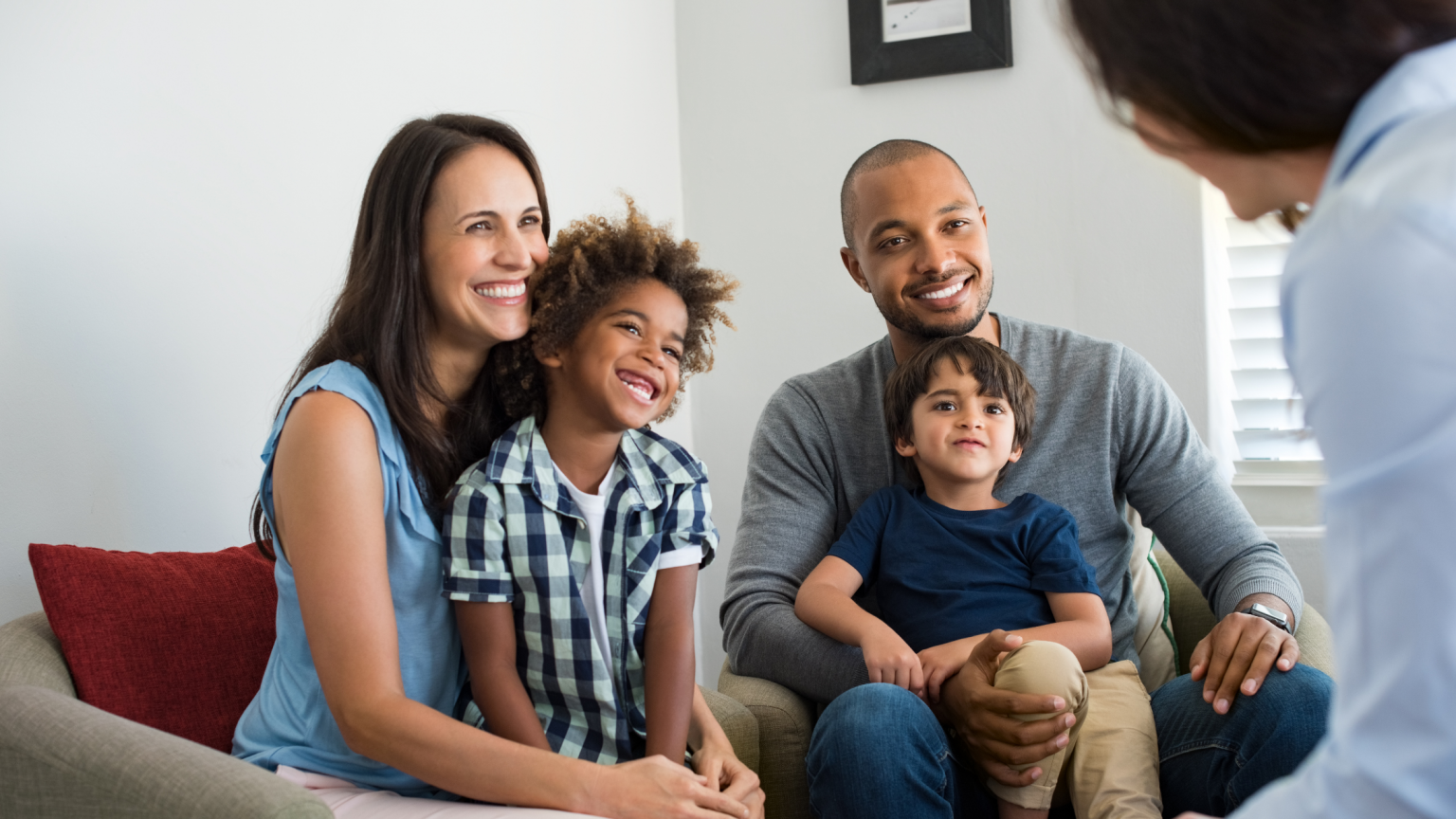 Happy family of four speaking with a mortgage loan consultant to purchase a home.