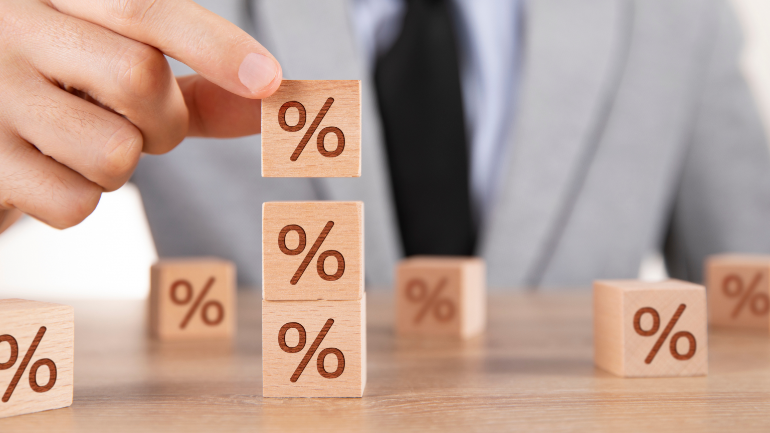 Stacking percentage symbol squares to symbolize rising interest rates.