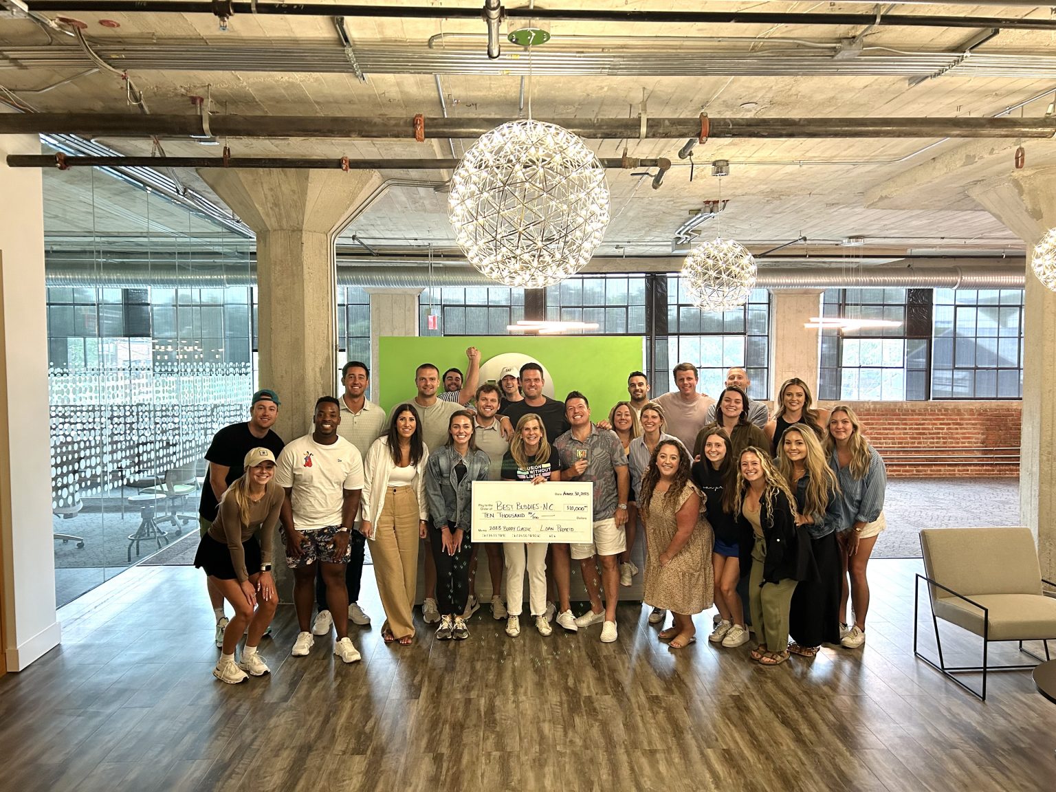 Loan Pronto employees posing with Best Buddies Director, Tammy Medlock, and a check for $10,000.